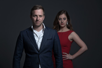 Fashion couple wearing a red dress and blue jacket. Young man an