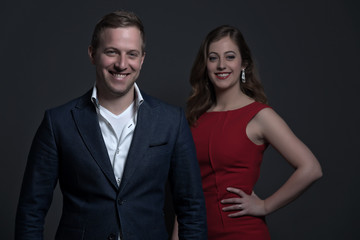 Fashion couple wearing a red dress and blue jacket. Young man an