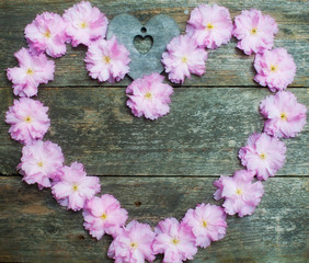 pink flowers and heart on the wooden background
