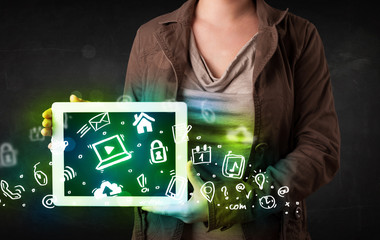 Person holding tablet with green media icons and symbols