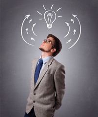 Young man thinking with arrows and light bulb overhead
