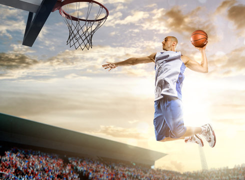 Basketball player in action on background of sky and crowd