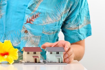 アロハシャツを着て住宅を説明する男性