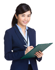 Asian businesswoman writing on clipboard