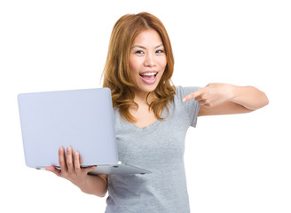 Happy woman pointing to laptop computer