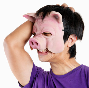 Man wearing pig mask with headache