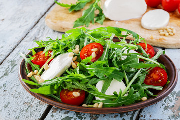 arugula salad with mozzarella cheese and cherry tomatoes