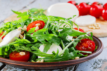arugula salad with mozzarella cheese and cherry tomatoes