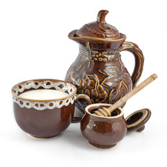 Milk with honey. Jug, a cup of milk and honey pot.