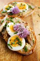 Sandwich with egg, mackerel and edible flowers of chives