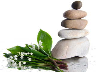 Composition of stacked pebbles with a bouquet of lilies