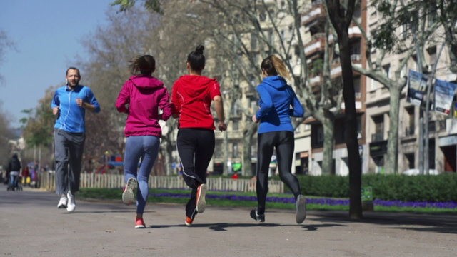 People jogging in the city, slow motion shot at 60fps, steadycam