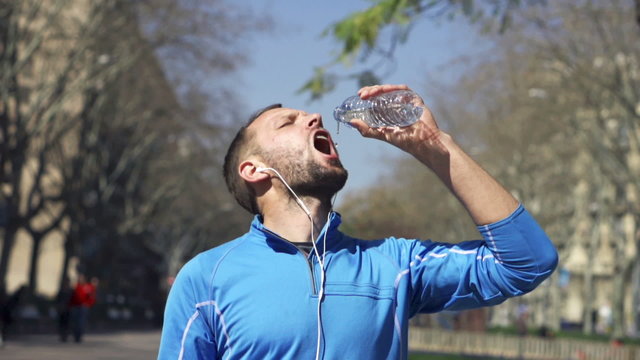 Jogger drinking water in park, slow motion shot at 240fps, stead