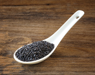 spoon with sesame seeds on a white background