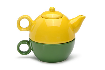 Set of a yellow ceramic teapot and green ceramic mug isolated on