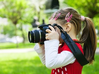 Girl who takes pictures with a photo camera in park