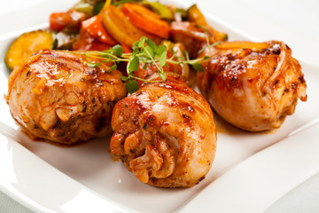 Grilled chicken legs and vegetables on white background