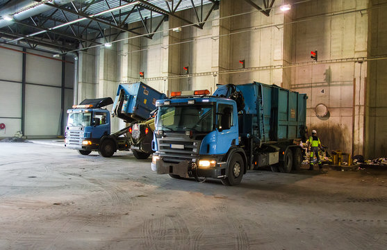 Trucks unloading garbage at recycle plant.