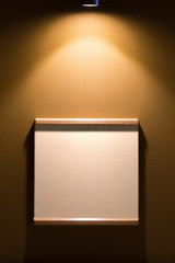 Empty frame on the wall with spotlight, for your text or picture