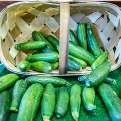 Fresh healthy green zucchini courgettes in basket on the marketp