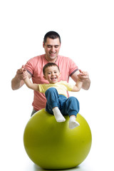 Fototapeta na wymiar father and kid son having fun with gymnastic ball
