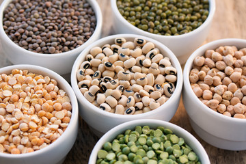 Six porcelain bowls with cereals on wooden desk