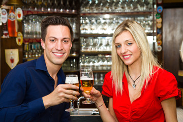 Beautiful couple enjoying beer in a pub 