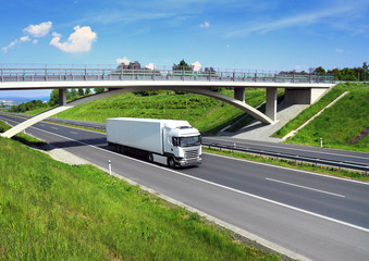 White truck driving around green meadows under the bridge. © Jaroslav Pachý Sr.
