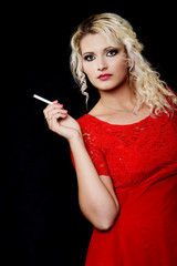 Belle jeune femme blonde fumant une cigarette