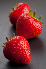 Three strawberries on black