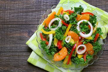 Salad with curly kale, paprika, mandarin and onions