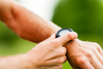 Trail runner looking at sport watch