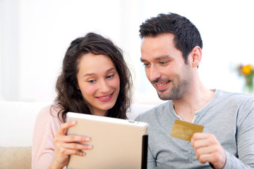 Young happy couple shopping on a tablet