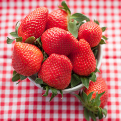 Small bowl filled with succulent juicy fresh ripe red strawberri
