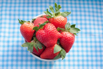 Small bowl filled with succulent juicy fresh ripe red strawberri