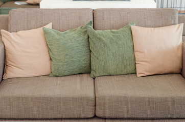 Four pillows on brown sofa