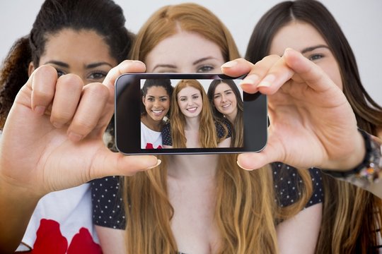 Composite image of hand holding smartphone showing