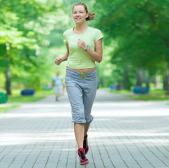 Woman jogging in city street park.