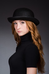 Fototapeta na wymiar Redhead girl in hat against grey background