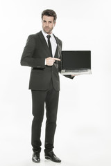 handsome man in a suit presenting a laptop with a blank screen