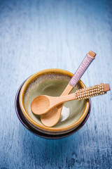 Spoons in ceramic bowl on wooden table
