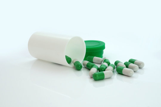 Green Pills An Pill Bottle On White Background