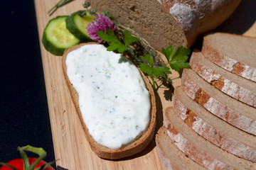 frisch geschnittenes Brot mit Kraeuterquark bestrichen 1
