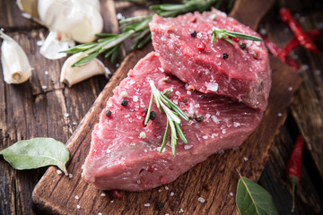 Raw beef steak on wooden table