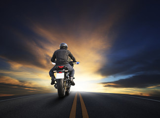 Naklejka premium młody mężczyzna jedzie duży motocykl na asfalcie wysoko przed