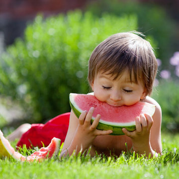 Boy, eating watermelon in the garden, summertime