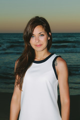 Young Beautiful Woman Standing On the Beach at Sunset