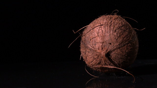 Coconut falling on black surface