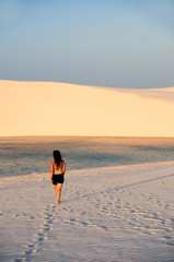 Hübsche junge Frau läuft durch den Sand auf Lagune zu