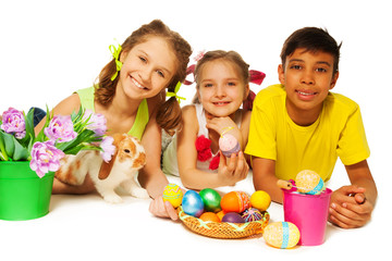 Three smiling kids together with Eastern eggs